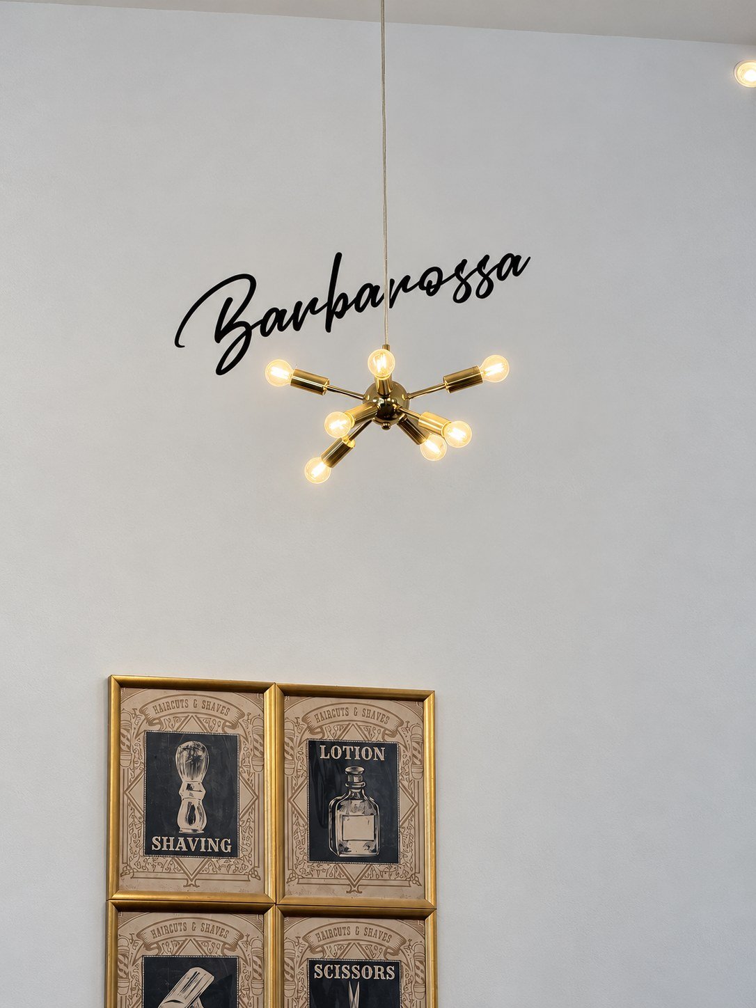 Messing-Leuchte mit Glühbirnen unter dem Barbarossa-Schriftzug an der Wand